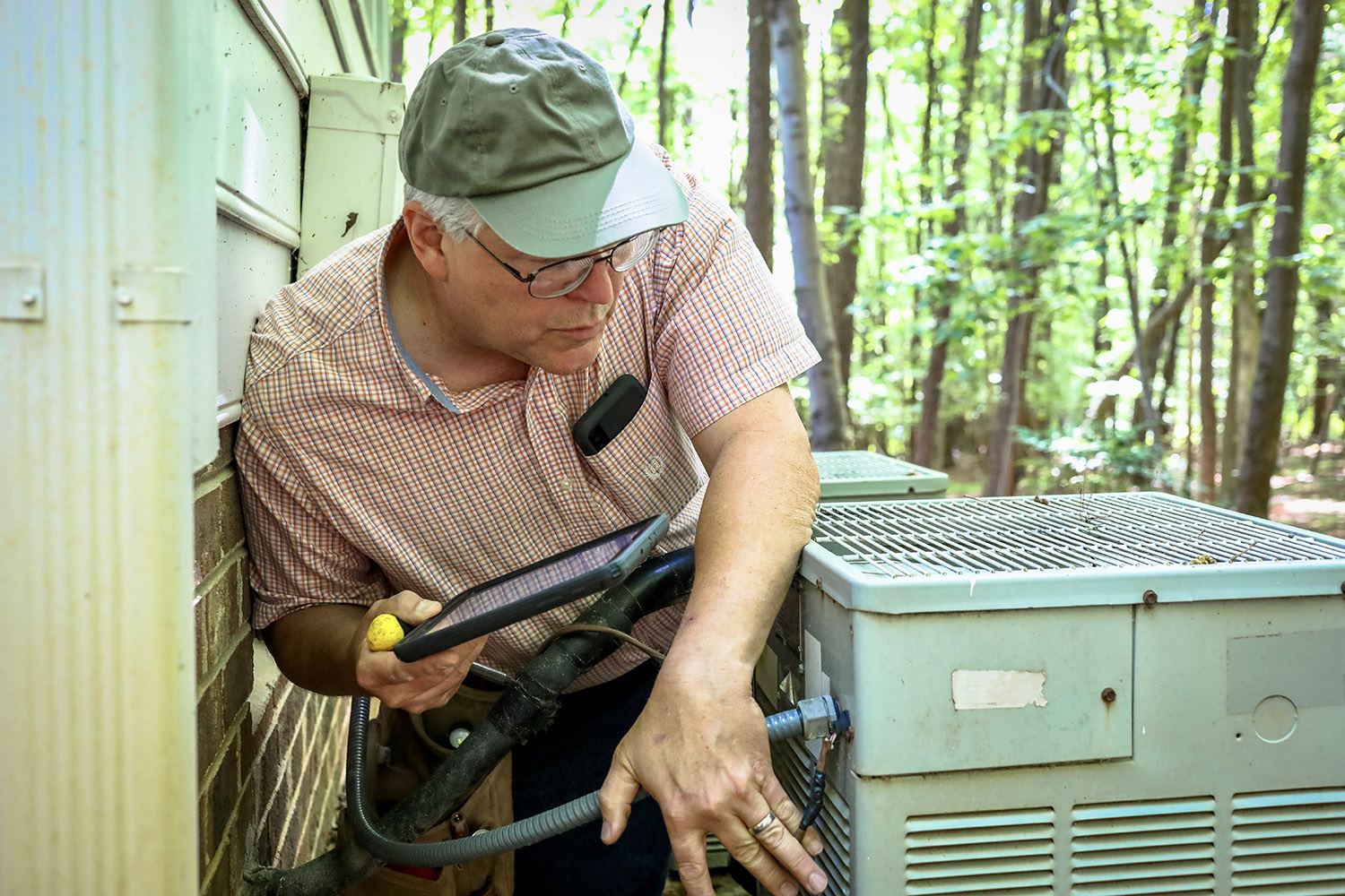 Mark Schwarz, one of our home inspectors, looking at an AC unit